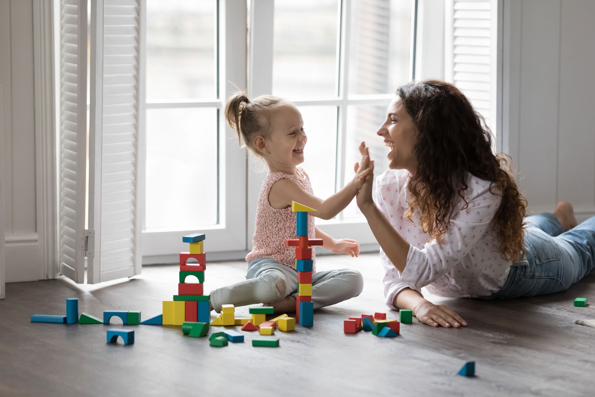 A physical therapist from Albury is conducting a play-based therapy session with a young girl.